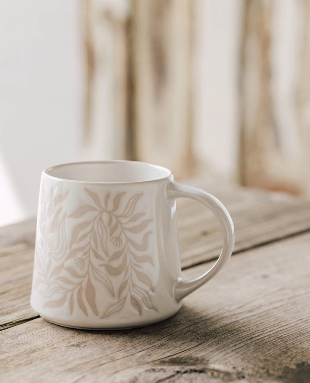 Berry Vine Driftwood Mug with botanical pattern on a rustic wood table