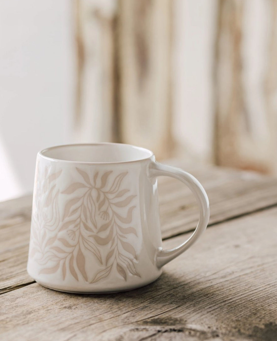 Berry Vine Driftwood Mug with botanical pattern on a rustic wood table