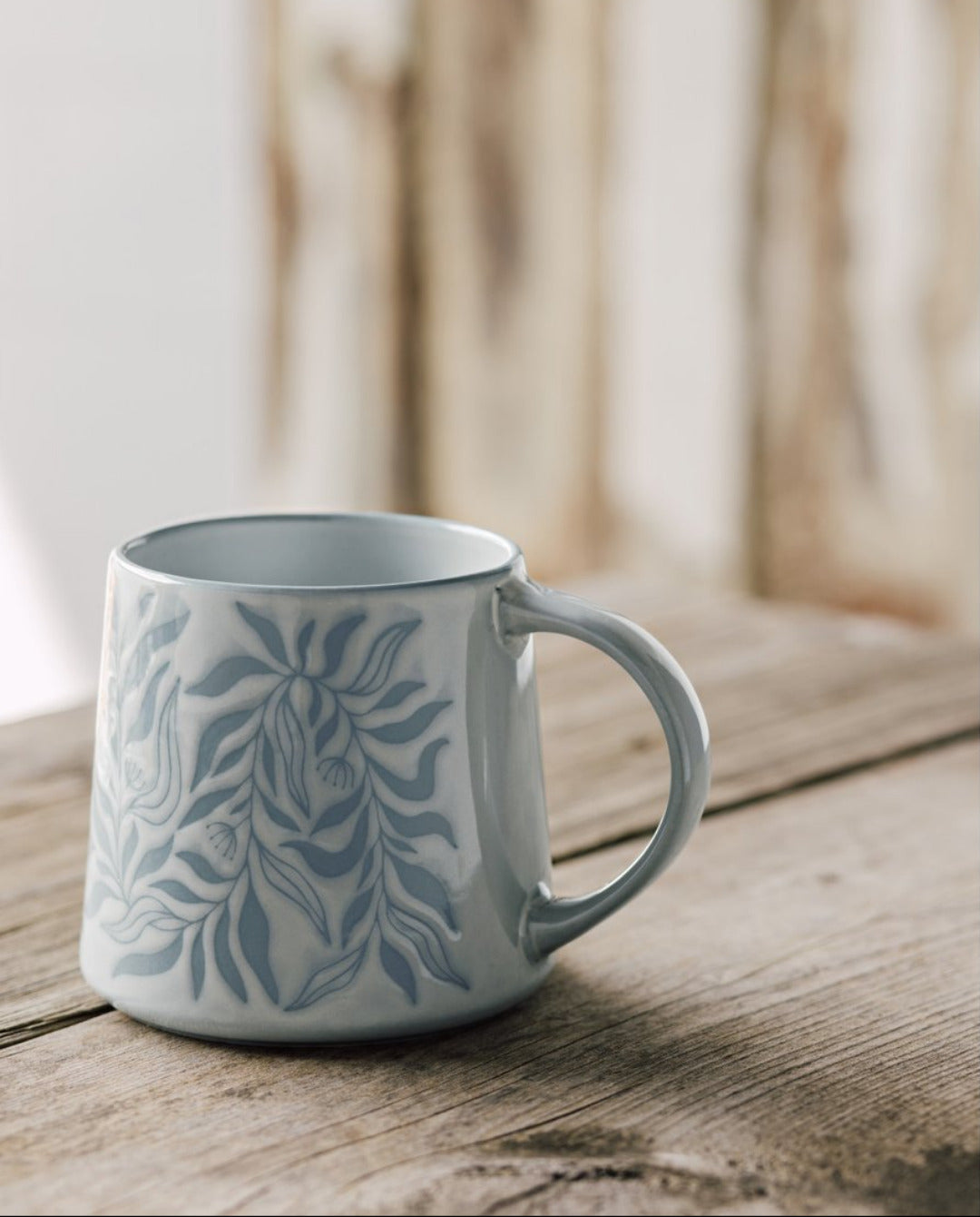 Berry Vine Ocean Mug with botanical pattern on a rustic wood table