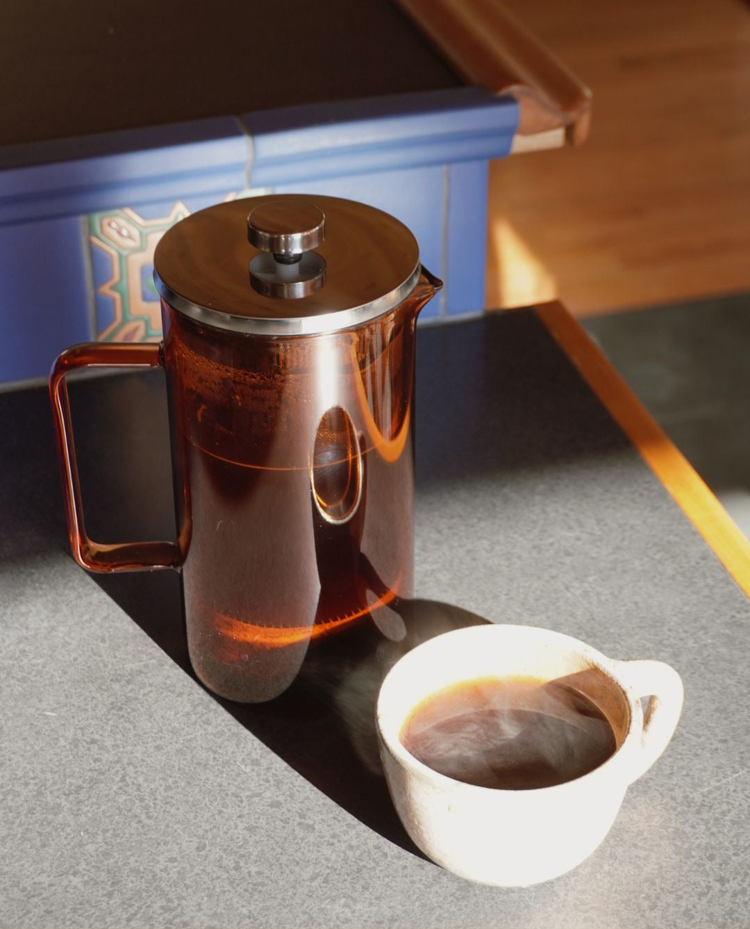 Freshly brewed coffee poured from a French Press Coffee Maker into a ceramic mug