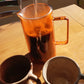 Hot water being poured into a glass French press coffee maker before brewing coffee