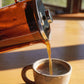 Serving freshly brewed coffee from a glass French press coffee maker