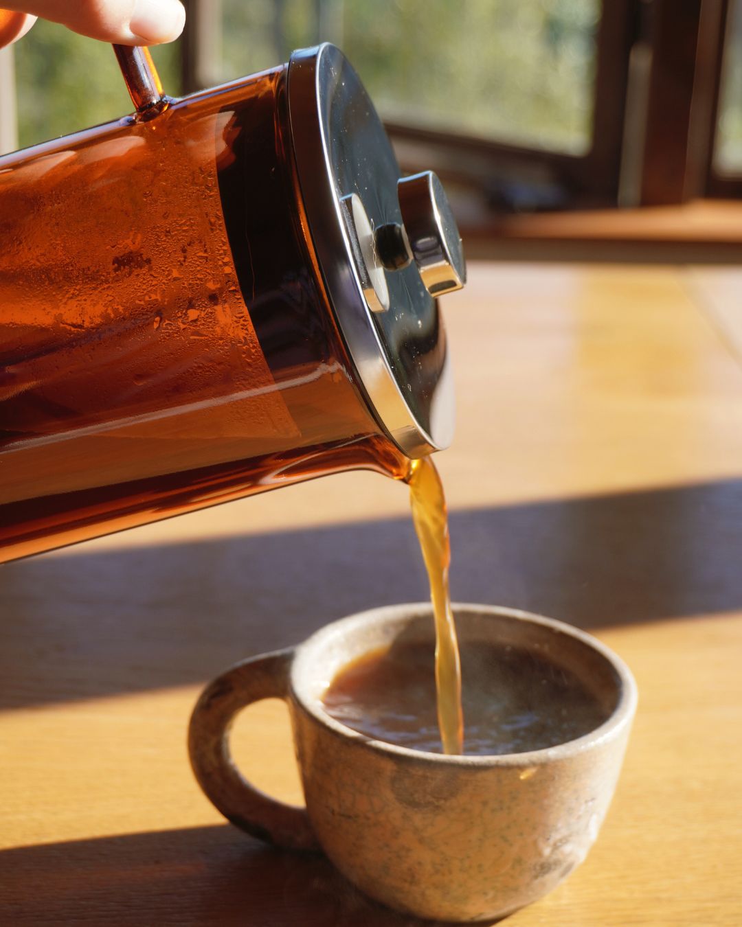 Serving freshly brewed coffee from a glass French press coffee maker
