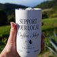 Reusable coffee tumbler being held with support your local coffee shop design