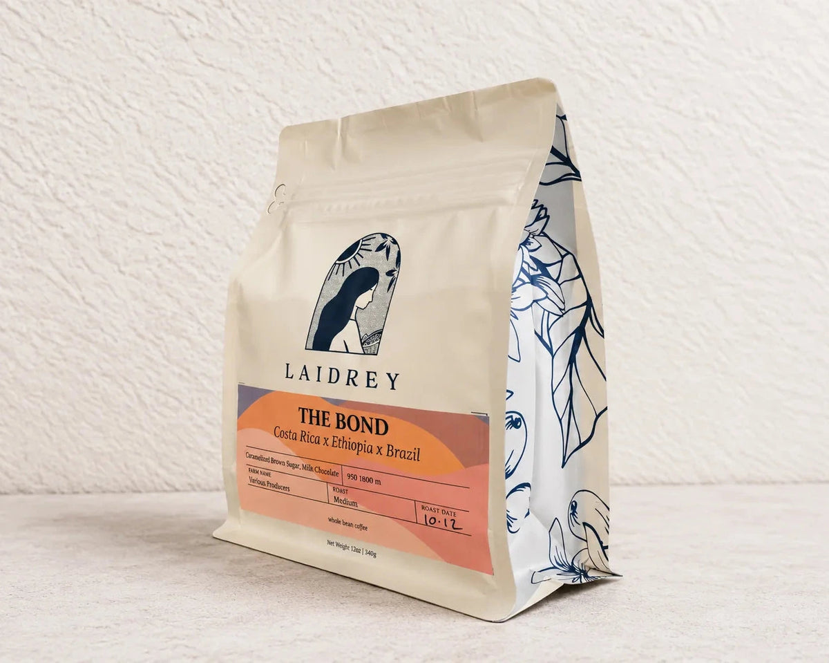 Angled view of The Bond medium roast coffee blend bag with caramelized brown sugar and milk chocolate tasting notes